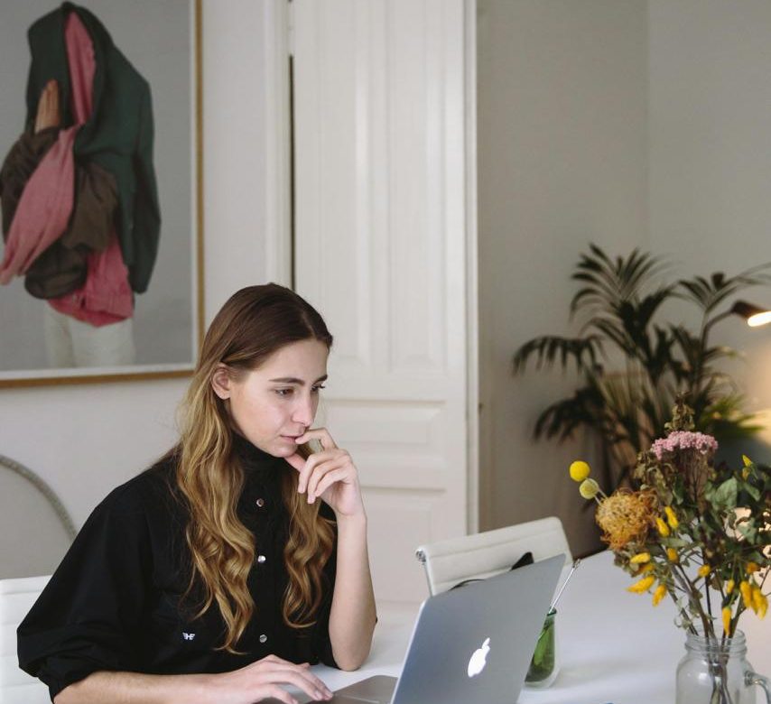A woman working at a desk. The background is homey