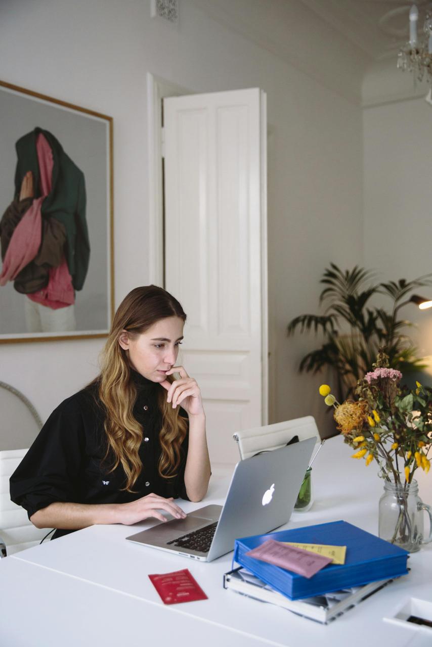 A woman working at a desk. The background is homey