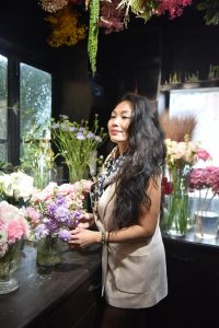 A woman standing and tending to flowers