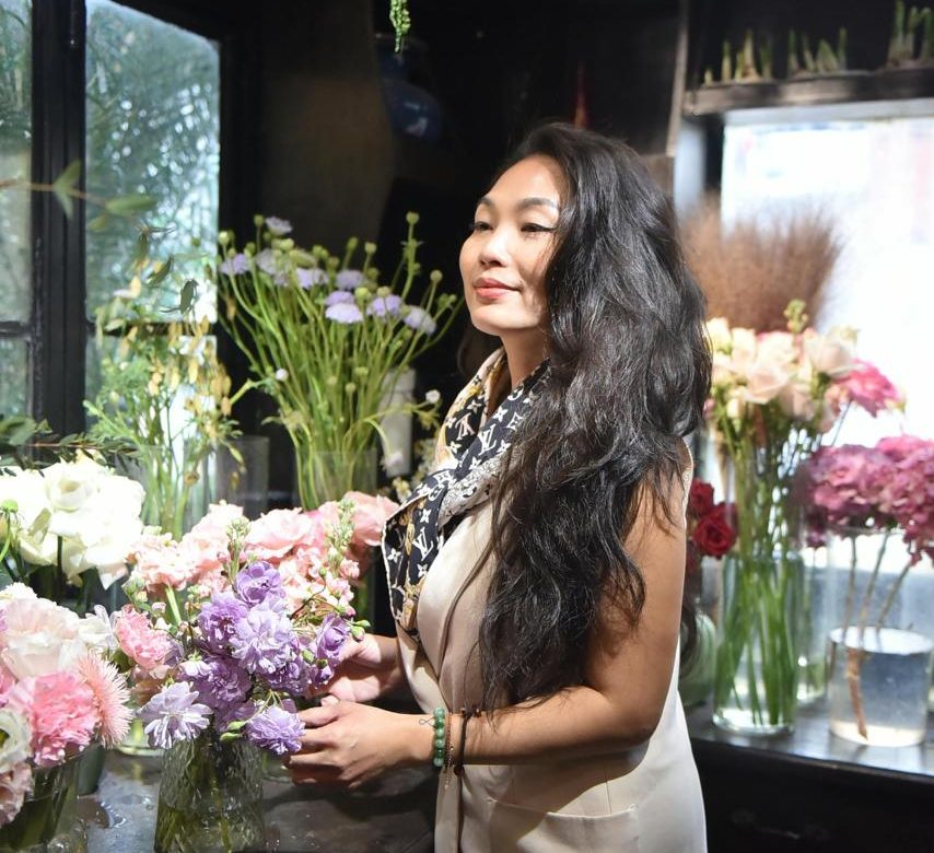 A woman standing and tending to flowers