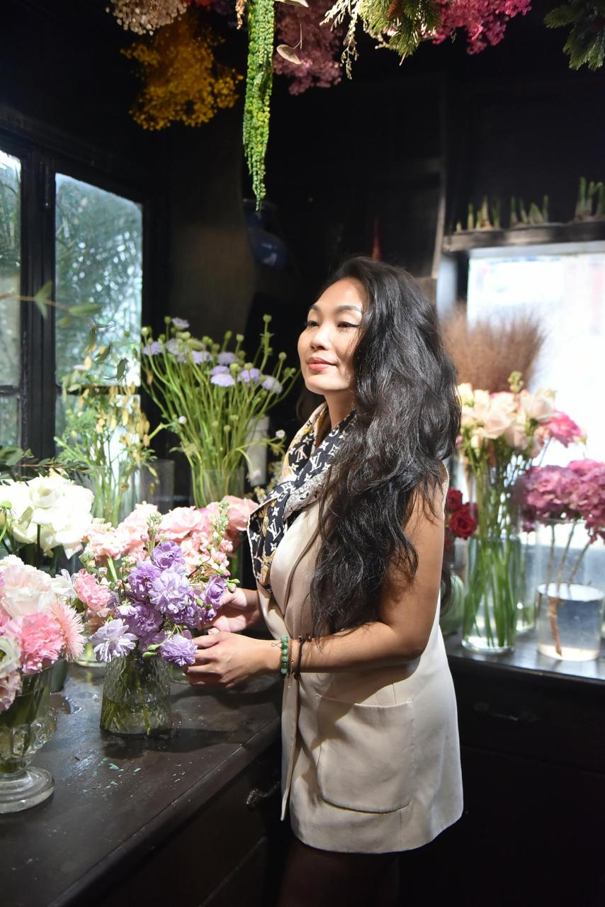 A woman standing and tending to flowers